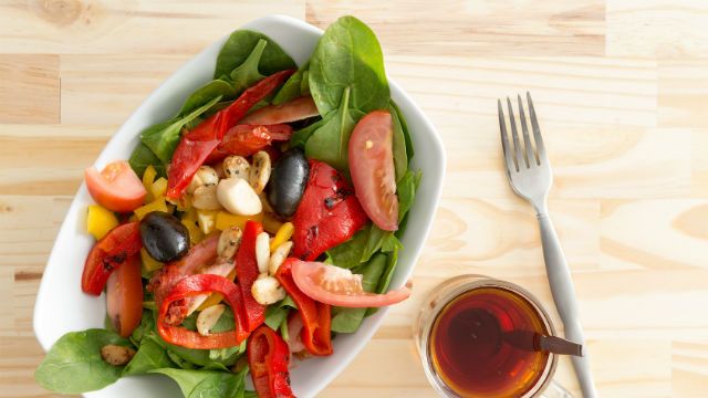 Baby spinach salad with olives, peppers and tomato
