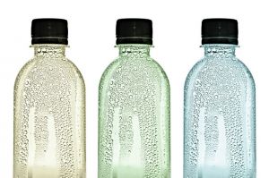 Three plastic bottles with water drops on skins