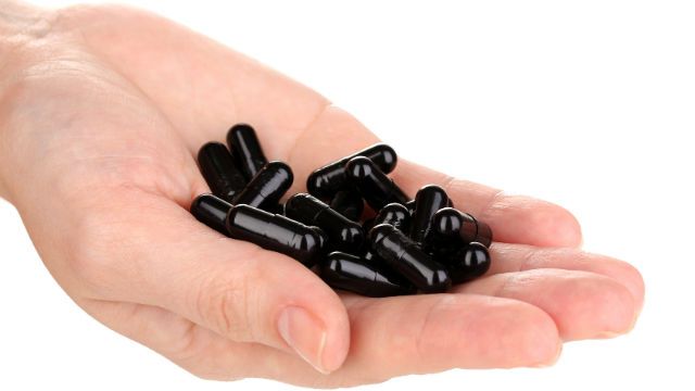 activated carbon in hand isolated on white