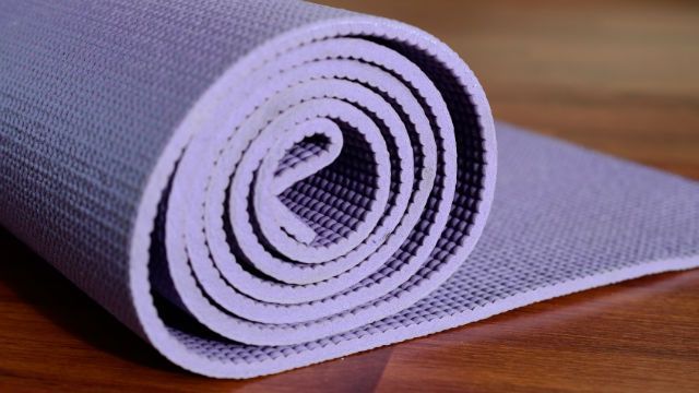 Yoga mat on wooden background