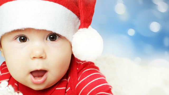 Surprised baby in Santa hat having fun, Christmas and Happy New