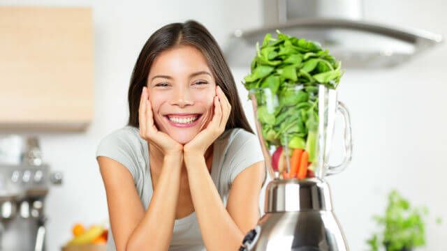 Green smoothie woman making vegetable smoothies