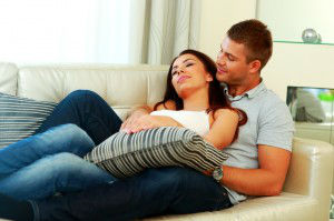Young beautiful couple relaxing on the sofa at home