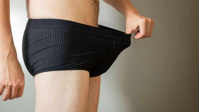 Man pulling his boxers. Concept photo of male sexuality&problems