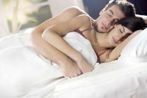 Couple sleeping and hugging on the bed in bedroom