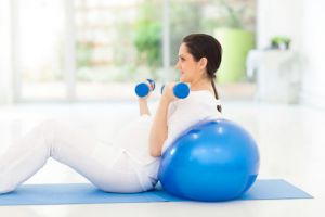 pregnant woman exercising with dumbbells