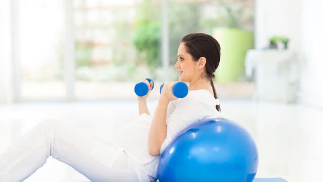 pregnant woman exercising with dumbbells
