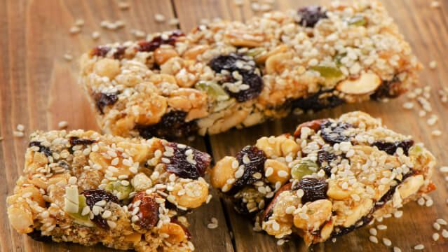 Healthy fruit and nut granola bars on a wooden table.