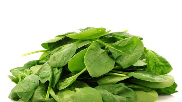bunch of fresh spinach leaves on a white background