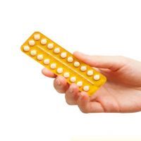 woman holding birth control pills