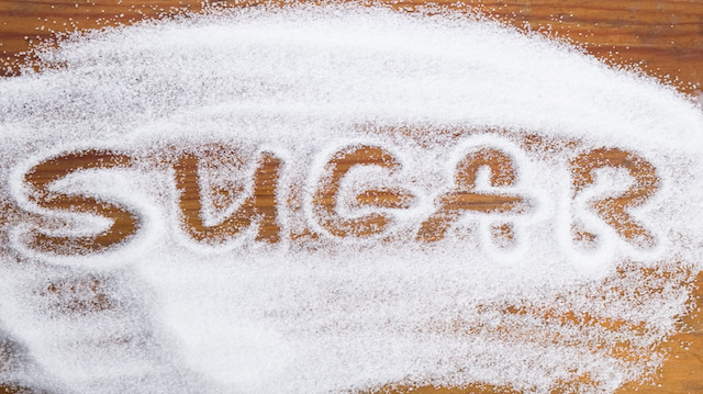 The word sugar written into a pile of white granulated sugar