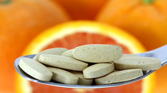 Film Coated Tablets of Vitamin C on the Orange background