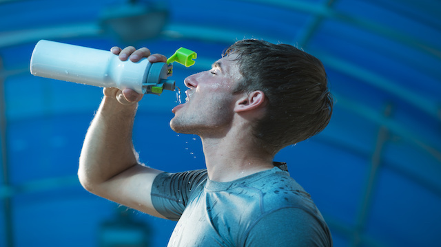 Athletic young man drinking water