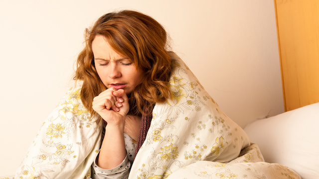 Sick woman cough in ved under blanket