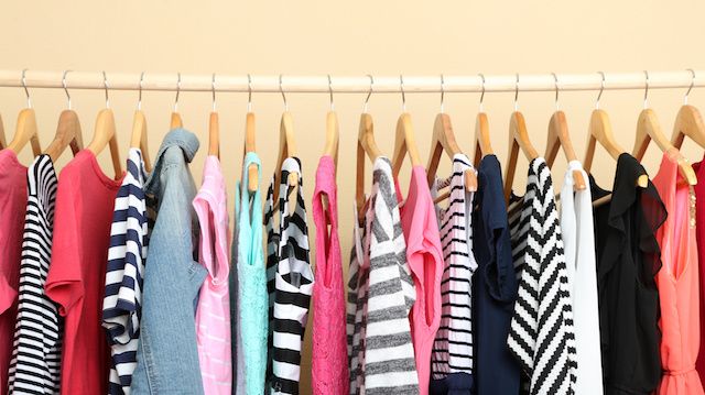 Colorful clothes on hangers in room