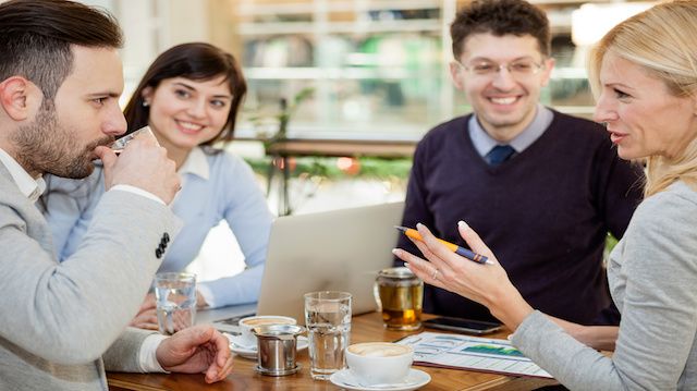 Group of business people meeting in coffee shop and holding a business presentation