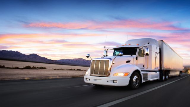 Truck and highway at sunset - transportation background