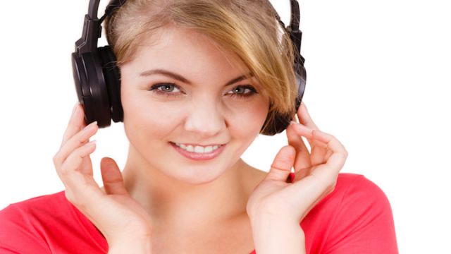 Woman in big headphones listening music isolated