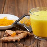 Turmeric curcuma drink with roots on table