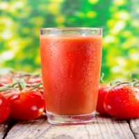 glass of tomato juice on wooden table