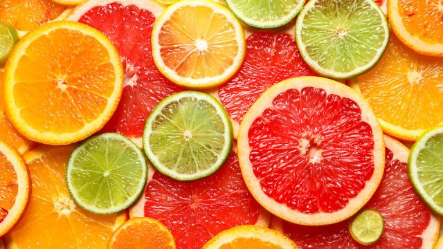 Slices of fresh citrus fruits as background, top view