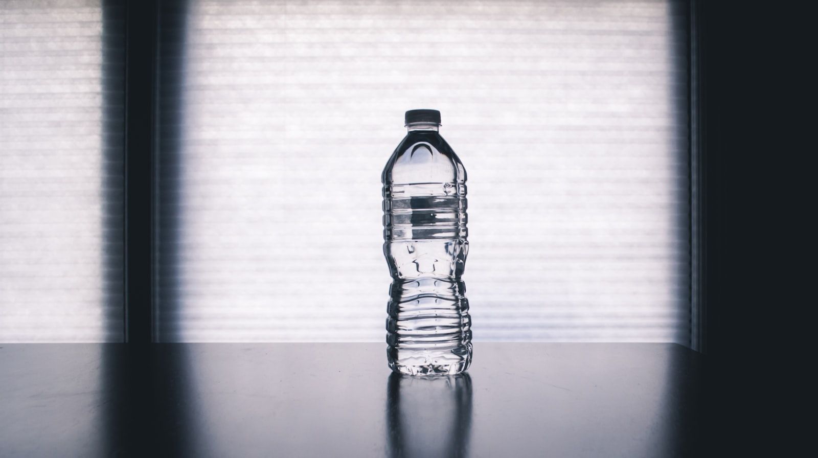 Clear glass bottles of water on a bright surface